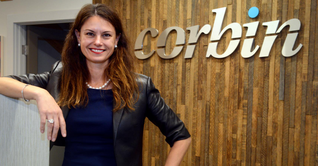 Founder & CEO, Rebecca Corbin at the Corbin sign in the Farmington, CT Headquarters